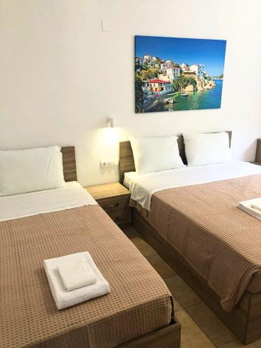two beds in a hotel room with a picture on the wall at Villa Elpiniki in Troulos