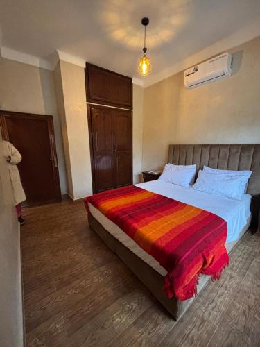 a bedroom with a large bed with a colorful blanket at Villa Ama in Marrakesh
