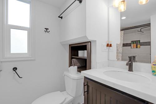 a white bathroom with a sink and a toilet at Tiny Blue at Yosemite Gateway in Groveland