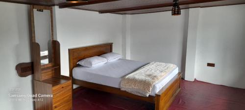 a bedroom with a bed with a wooden headboard at Himidiri Villa in Nuwara Eliya
