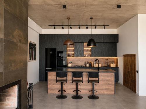 a kitchen with a island with bar stools at Luxury Villa #1 in Tabakhmela