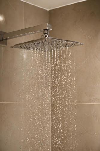 a shower with a shower head with a shower curtain at View Lounge Hotel in As Sulaymānīyah