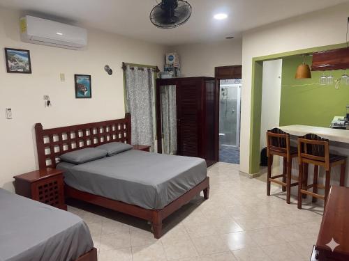 a bedroom with a bed and a kitchen with a table at Casa Caribe in Bacalar
