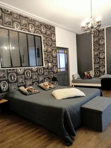 a bedroom with a large bed and a wall of plates at La maison de Thiré in Thiré