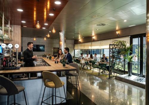 a group of people sitting at a bar in a restaurant at Hotel Princesa De Eboli in Pinto