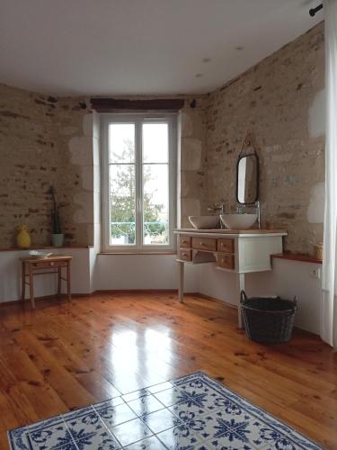 a bathroom with two sinks and a window at La maison de Thiré in Thiré