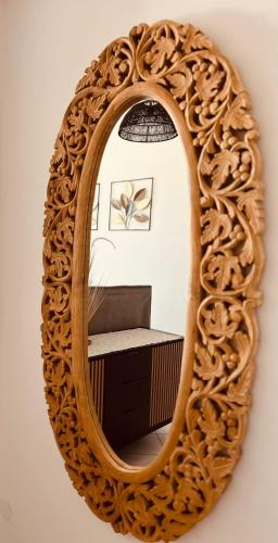 a mirror with a wooden frame on a wall at Apartmán GREEN in Vysoké Mýto