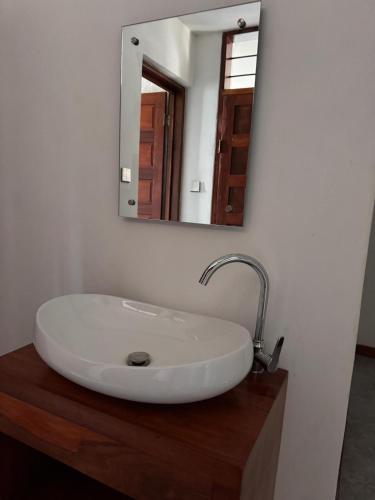 a bathroom sink with a mirror on a wooden counter at 3 bedroom house with a mountain view in Mbeya