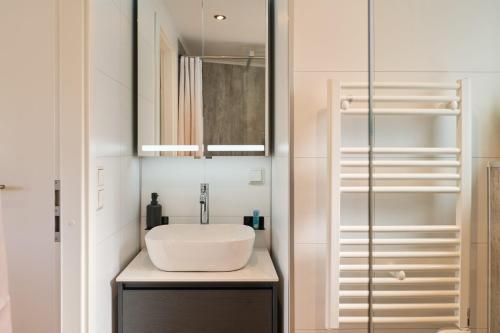 a bathroom with a white sink and a mirror at Ostseecamp Haus Im Eck 142 mit kostenfreier Saunanutzung in Scharbeutz