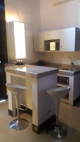 a kitchen with a counter and two stools in it at Hotel Acropolis Callao in Lima