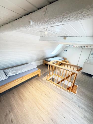 an attic room with two beds and wooden floors at Fischerhus in Fehmarn