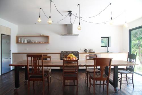 cocina y comedor con mesa de madera y sillas en BIG.SHED.HOUSE, en Huonville