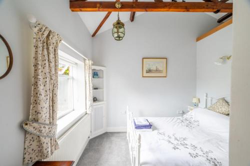 a bedroom with a bed and a window at Ballygate Stable in Beccles