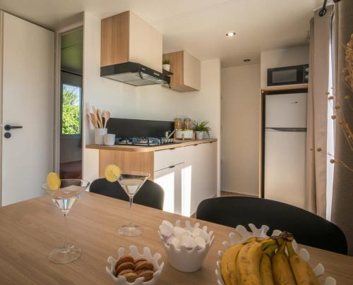 a kitchen with a wooden table with bananas on it at Camping Cabestan in Bretignolles-sur-Mer
