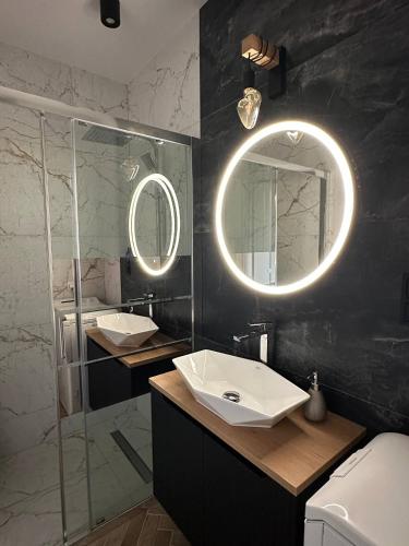 a bathroom with two sinks and a mirror at Baltic Porto M66 in Gdańsk