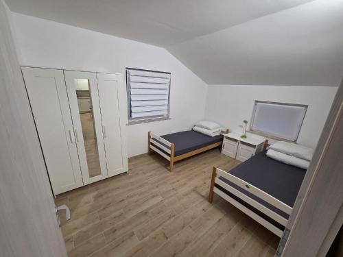 a small room with two beds and a window at Apartma Pri Stevotu in Deskle