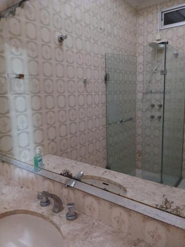 a bathroom with a sink and a mirror at Paraíso com piscina e lareira no centro in Serra Negra