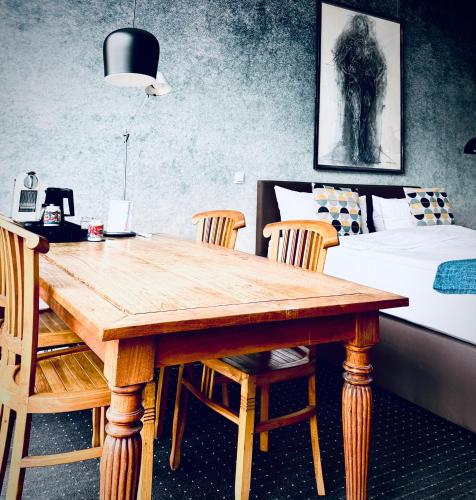 a dining room with a table and chairs and a bed at Aparthotel Flughafen Leipzig in Freiroda
