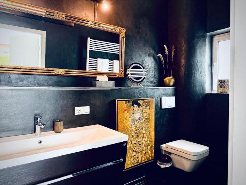 a bathroom with a sink and a mirror and a toilet at Aparthotel Flughafen Leipzig in Freiroda