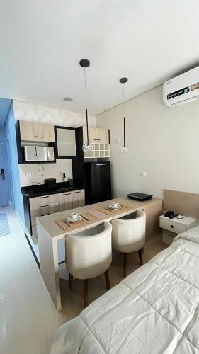 a kitchen and dining room with a table and a bed at 809 - Studio Moderno no Centro-Batel in Curitiba