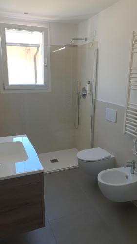 a bathroom with a toilet and a sink and a shower at Residence Lido di Dante in Lido di Jesolo