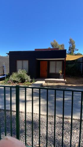a black house with a fence in front of it at Ritoque lodge in Vina del Mar
