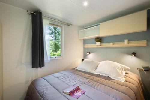 a bedroom with a bed with a window and a window at Camping El Canto la Gallina in Valdemaqueda