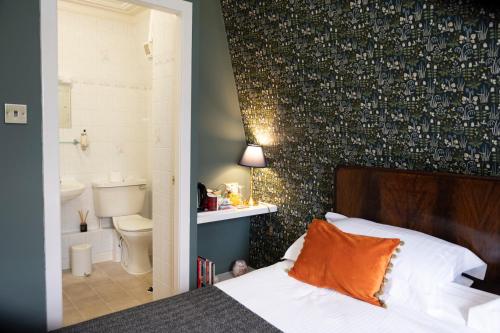 a bedroom with a bed and a bathroom at Leven House Bed and Breakfast in Crieff