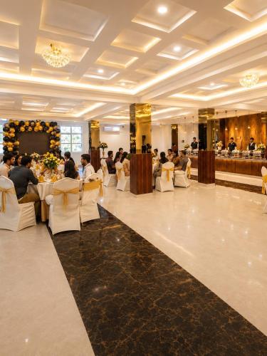 a group of people sitting at tables in a restaurant at Velara Hotel & Banquet in Gwalior
