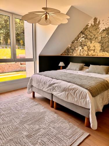 a bedroom with a large bed and a ceiling fan at Ty Toralann in Guipavas