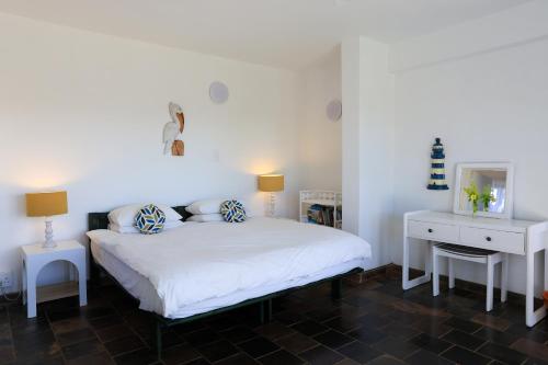 a bedroom with a white bed and a white desk at Seaward Studio Suite in Ramsgate