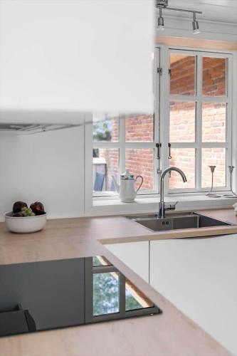 a white kitchen with a sink and a window at 2808-Romo-Lejrbjergvej-4 in Høm