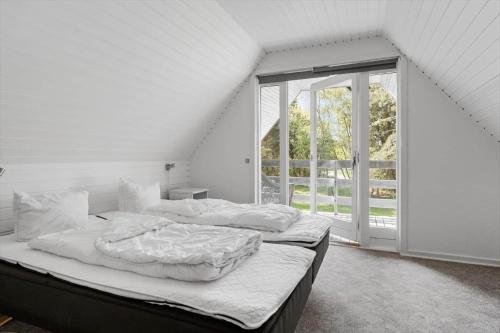 a bedroom with two beds and a large window at 2808-Romo-Lejrbjergvej-4 in Høm