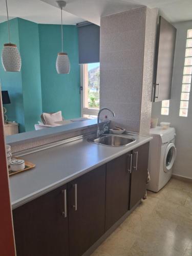 a kitchen with a sink and a washing machine at Albir Sunshine Apartments in Albir