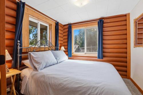 a bedroom with a bed and two windows at Hayden Lake Oasis in Hayden