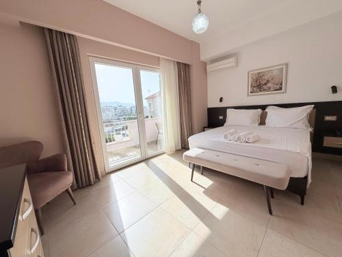 a bedroom with a large bed and a large window at Aparthotel PAJA Ksamil in Ksamil