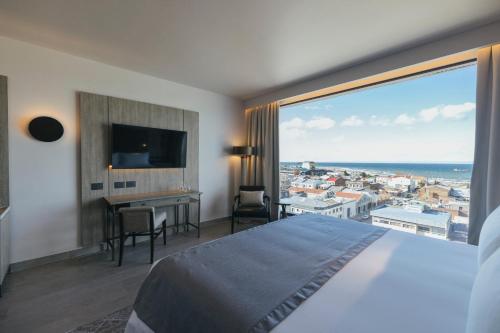 a hotel room with a large bed and a large window at Hotel Cabo De Hornos in Punta Arenas