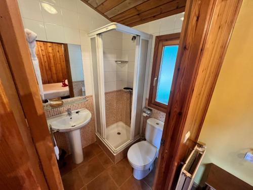 a bathroom with a toilet and a sink at Camping El Canto la Gallina in Valdemaqueda