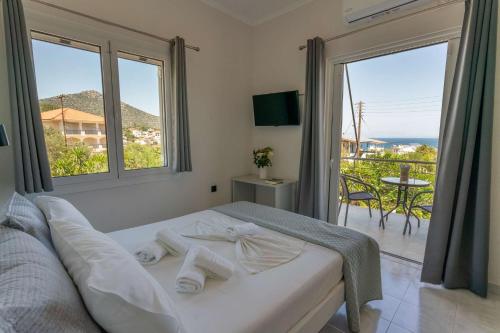 a bedroom with a bed and a balcony with a view at Laloudaki Apartments in Tyros