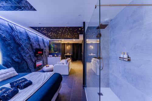 a bedroom with a bed and a glass shower at Le Céleste - Suite romantique immersive climatisée, sauna et spa privatif in Lesparre-Médoc