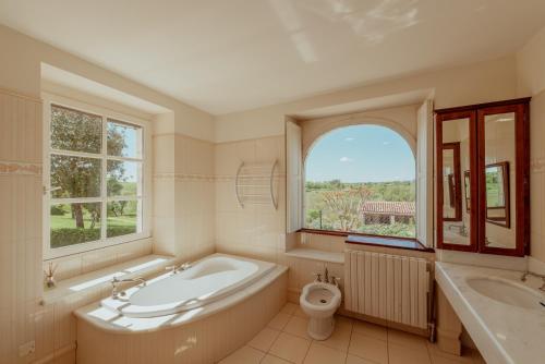 a bathroom with a tub and a sink and a toilet at Vila Cabanes 46 in Le Montat