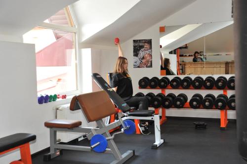 a woman sitting on a bench in a gym at Туристично розважальний комплекс "Стіжок" in Berehomet