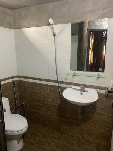 a bathroom with a toilet and a sink and a mirror at Sần's House in Lao Cai