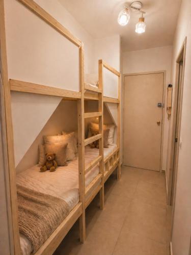 a bedroom with two bunk beds with a teddy bear at Location Cap d'Agde Aurélie in Cap d'Agde
