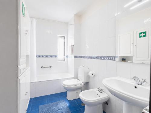 a white bathroom with a toilet and a sink at Refúgio do Vidoeiro in Geres