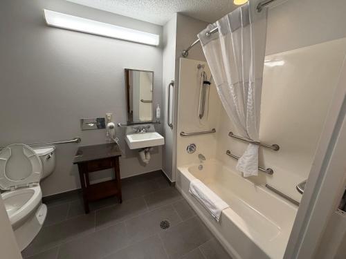 a bathroom with a toilet and a sink and a shower at Microtel Inn & Suites in Dickson City