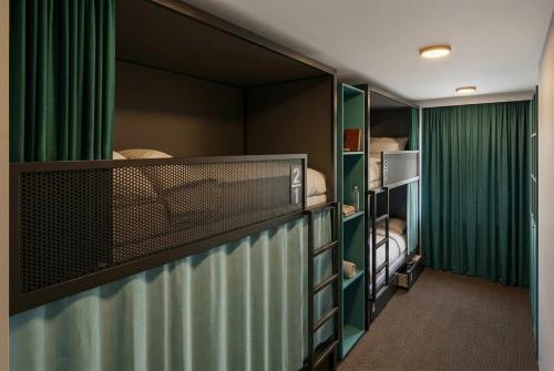 a room with two bunk beds and green curtains at Auberge du Parc in Delémont