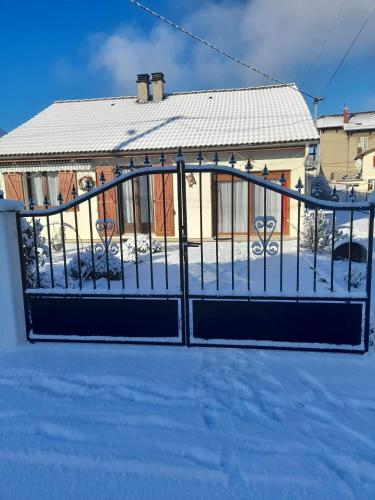 a gate in the snow in front of a house at Chambre chez Danuta in Champagnole