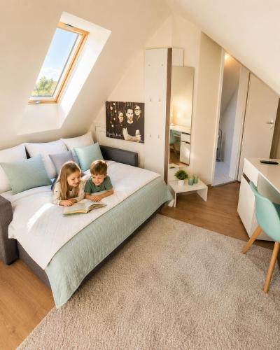 two children sitting on a bed in a bedroom at Hévíz Springs - Kehidakustány in Kehidakustány