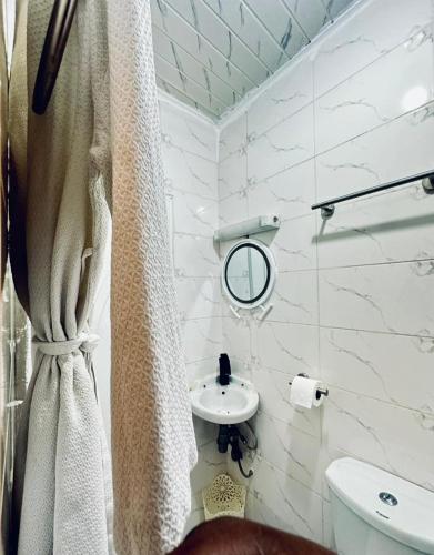 a bathroom with a shower curtain and a sink at Dyden luxury appartement in Douala